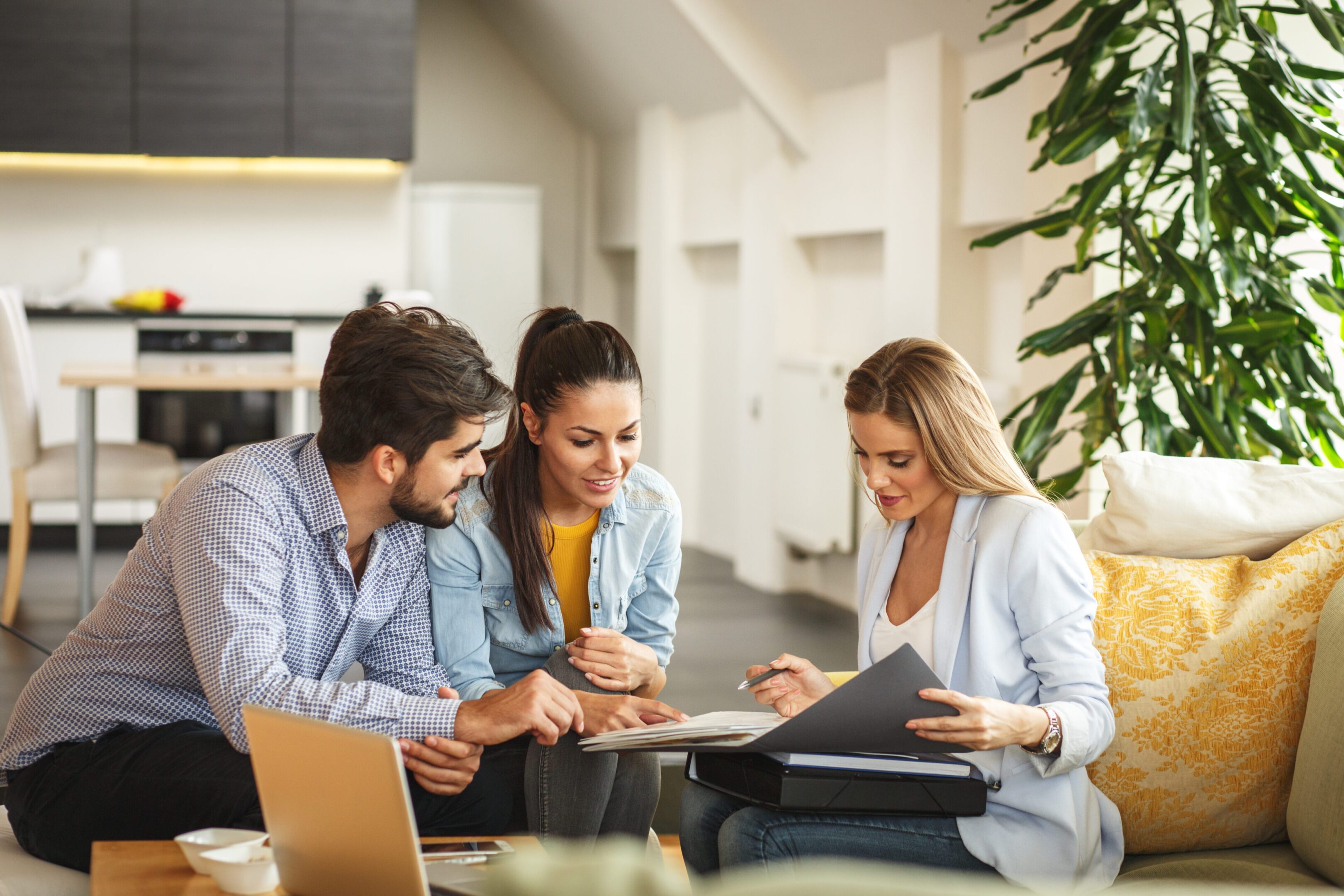 Real Estate Female Real Estate agent offer home ownership and life insurance to young couple.